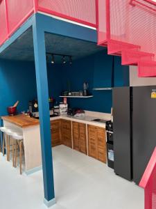 恰洛克拉姆Adika - The beachfront Loft的一间设有蓝色墙壁和木制橱柜的腿部厨房