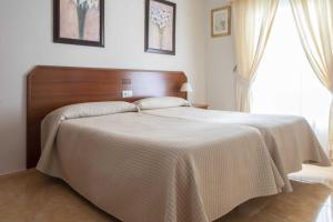 卡萨韦梅哈雄鸡酒店的一间卧室配有一张大床和木制床头板