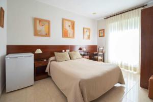 卡萨韦梅哈雄鸡酒店的一间卧室设有一张大床和一个窗户。