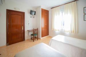 卡萨韦梅哈雄鸡酒店的一间卧室配有一张床、一张桌子和一个窗户。