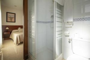 卡萨韦梅哈雄鸡酒店的浴室设有玻璃淋浴间和卫生间