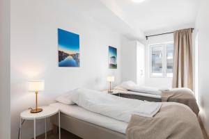 特隆赫姆Forenom Serviced Apartments Trondheim的白色客房的两张床,配有两盏灯