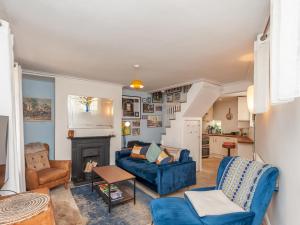 利兹Pass the Keys Wonky Cottage with amazing garden的客厅设有蓝色的沙发和壁炉