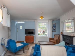 利兹Pass the Keys Wonky Cottage with amazing garden的客厅配有蓝色椅子和沙发