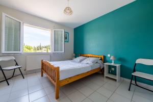 卡尔卡松Gîte L'Orée du Lac的一间卧室设有一张床和蓝色的墙壁