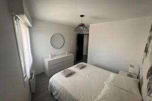 比亚里茨Apartment hyper-center Biarritz with parking的白色卧室配有床和镜子