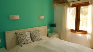 哈维亚Villa Sal y Mar - Jávea ! Freshly Renovated !的一间卧室配有一张蓝色墙壁的床和一扇窗户