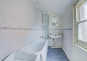 绍斯沃尔德54 Stradbroke Road的白色的浴室设有浴缸和水槽。