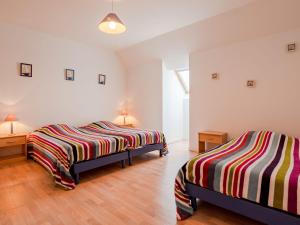 Hauteville-sur-MerHoliday Home Néroli - HSM200 by Interhome的配有白色墙壁和木地板的客房内的两张床