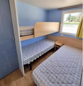 LorrisDOMAINE DE LA GRANGE DES CHAMPS的小房间设有两张双层床和窗户