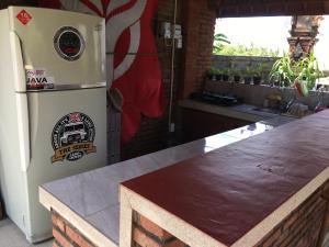 克拉玛斯Kubu Pering的厨房配有白色冰箱,设有桌子