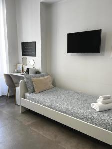 庞贝Gioielli House Pompei的一间房间,配有一张床铺,墙上配有电视