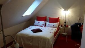桑德Auf dem alten Deich的卧室配有带红色枕头的白色床