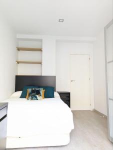 塞维利亚m-odern的卧室配有白色的床和白色橱柜。