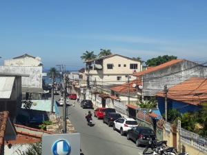大伊瓜巴Loft PARIS para Casais, em Iguaba Grande, 150 metros da praia的一条城市街道,路边有汽车停放