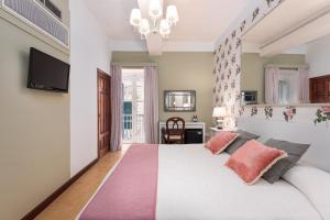 瓦莱塔卡斯蒂利亚酒店的卧室配有带粉红色枕头的大型白色床