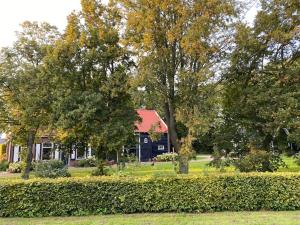 heinkenszandB&B Boerderij De Vaete - Duurzaam genieten in de zak van Zuid-Beveland的院子前有树木的房子