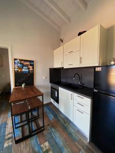 VagiaThe Dona House的厨房配有白色橱柜和黑色冰箱。