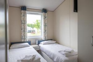 布德Bude Holiday Resort的小型客房 - 带2张床和窗户