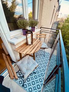 布达佩斯Mrs. Columbo's Flat的阳台配有木桌和玻璃栏杆。