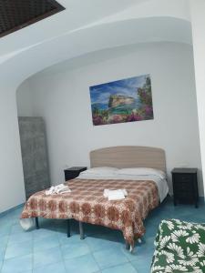 伊斯基亚Hotel Mareluna Ischia的卧室配有一张床,墙上挂有绘画作品
