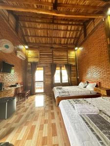 吉仙Sunny Eco Lodge的大房间设有两张床和木制天花板
