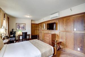 贝科莫格兰德酒店的一间卧室配有一张床、一台电视和一张书桌