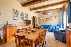 萨奈特Gozo Rustic Farmhouse with stunning views and swimming pool的厨房以及带木桌的起居室。