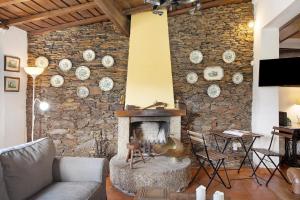 BarqueirosAzenha da Lagoa Negra的客厅设有带壁炉的石墙