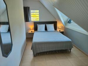 勒拉芒坦La Perle Caribéenne的一间卧室配有一张带两盏灯的床和一扇窗户。