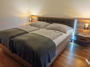 沃尔特湖畔佩莎赫Apartment Luxury Sunrise Appartement by Interhome的卧室内的一张大床,配有两盏灯