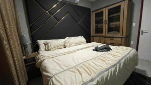 帕拉马里博Pavema Apartments的一间卧室配有一张大床和木制床头板