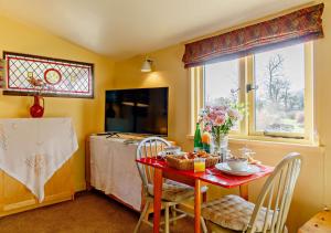 StradbrokeOwls Nest的厨房配有红色的桌椅和窗户