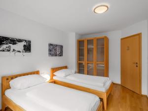 巴德加斯坦Chalet Chalet Pflaume by Interhome的白色墙壁客房中的两张单人床