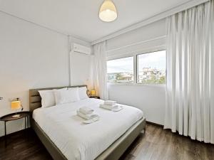 雅典Omorfokklisias Apartments by Verde的白色卧室,配有带毛巾的床