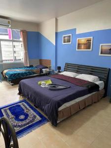 卡塔海滩San Antonio Beach Guesthouse & Restaurant的一间卧室设有一张大床和蓝色的墙壁