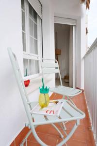 拉海瑞德拉Apartamento El Sol Naciente的门廊上的白色摇椅