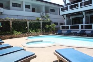 拉迈拉迈完美度假酒店的一座带躺椅的游泳池位于大楼旁