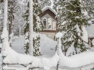 锡尔卡Holiday Home Levin taiga 18 a by Interhome的树前的雪覆盖的房子