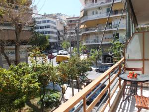 雅典Μια ρετρό γωνιά στην Ακρόπολη, 5 λεπτά απ' το μετρό的阳台配有桌子、树木和街道