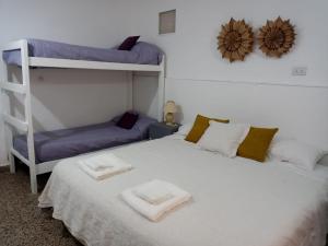 卡特里耶尔Cacique Catriel "PLANTA BAJA" check-in flexible的一间卧室配有两张双层床,床上配有毛巾