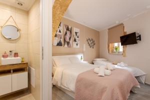 干尼亚Mitos mini suites的一间卧室配有两张床和镜子