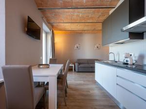 CalossoApartment Il sogno di Elisa-3 by Interhome的厨房以及带白色桌椅的起居室。