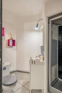 沃昂夫兰Studio indépendant et chambres dans maison avec jardin-Carre de Soie的白色的浴室设有卫生间和水槽。