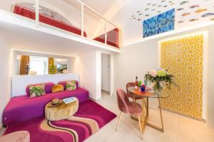 卡普里Suite Belvedere Capri Exclusive Rooms的客厅配有紫色沙发和桌子