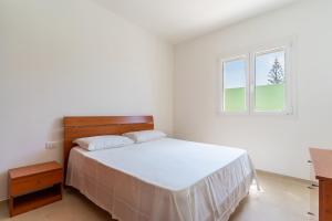托雷圣乔万尼乌Appartamenti Li Paduli的白色的卧室设有床和窗户