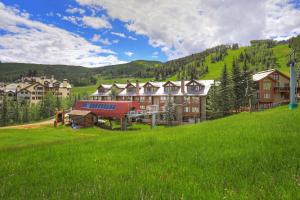 比弗河The Osprey at Beaver Creek, a RockResort的绿草丛生的山丘上的一群房子