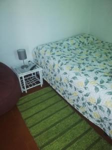塞辛布拉Casa da Praia Alfarim的一间卧室配有一张床和一张带台灯的桌子