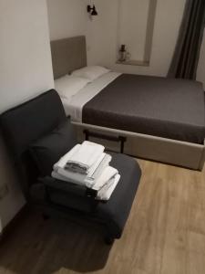 布林迪西Largo Otranto - Guest House的一间卧室配有两张床和一张带毛巾的椅子
