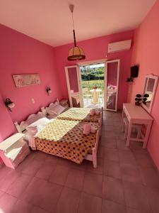罗达Telis Apartments One的一间卧室配有一张床和粉红色的墙壁